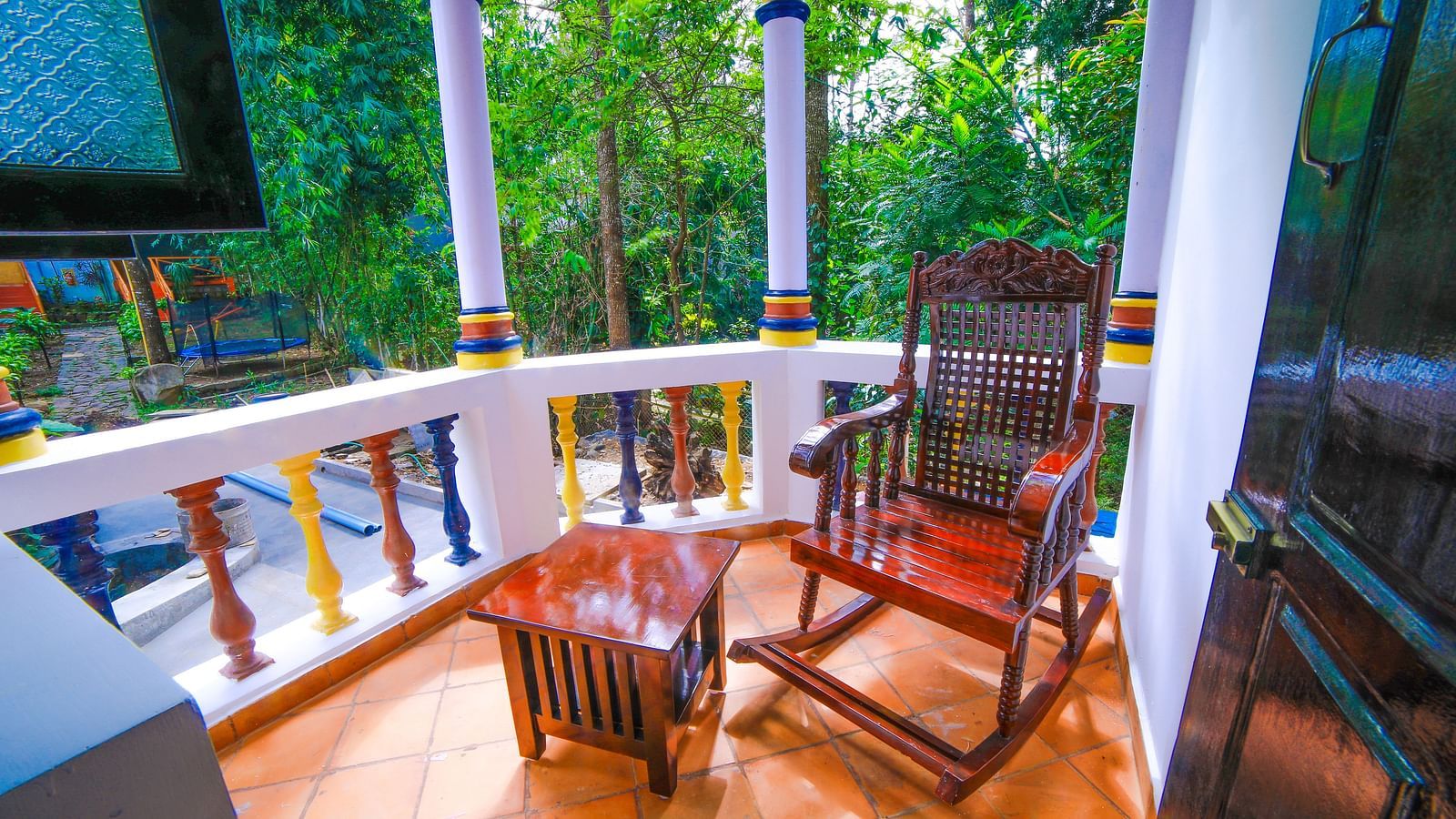 Image of a balcony with a rocking chair and a wooden table in front at WOW Bison Woods.